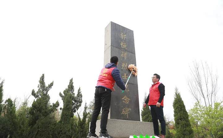 职工志愿者对纪念碑进行清理、擦拭.jpg